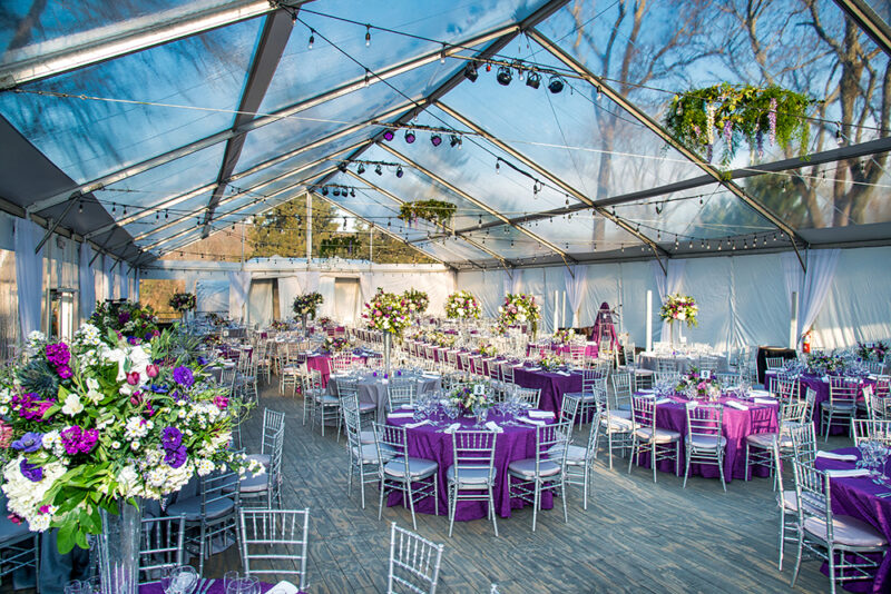 Wedding reception set up underneath a clear top tent.